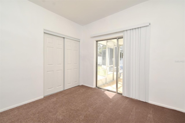 unfurnished bedroom with access to exterior, a closet, and carpet flooring