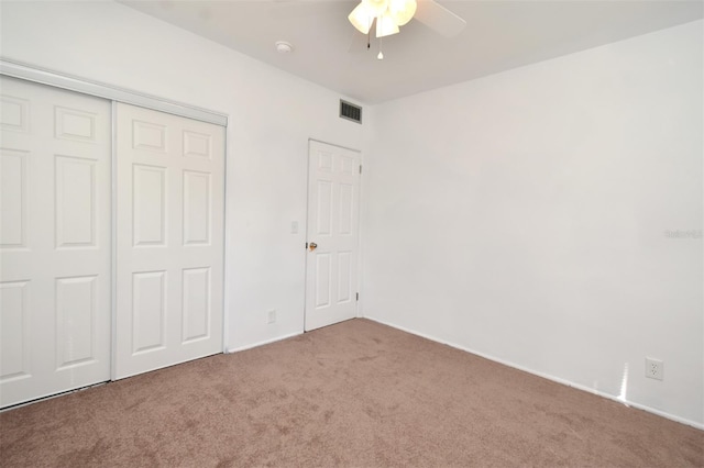 unfurnished bedroom featuring a closet, ceiling fan, and carpet