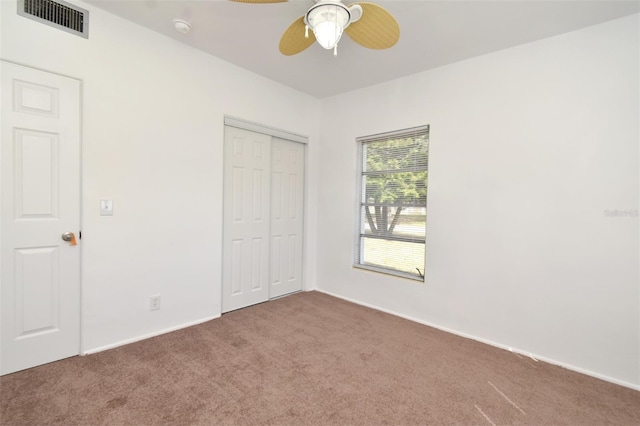 unfurnished bedroom featuring ceiling fan, carpet floors, and a closet