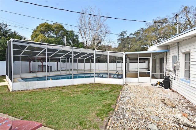 view of pool with a lanai, a sunroom, and a lawn