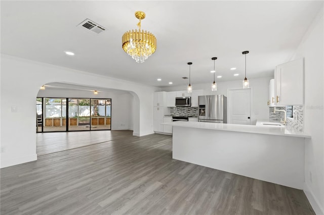 kitchen with white cabinetry, stainless steel appliances, light countertops, and open floor plan