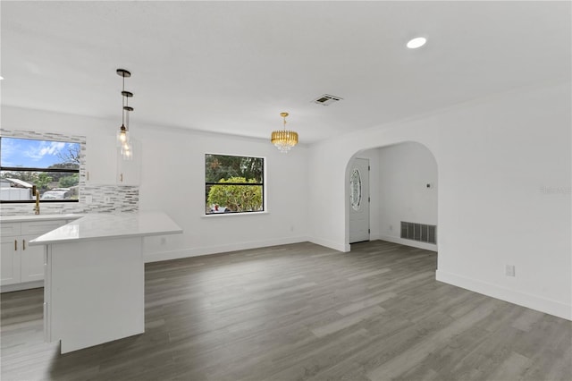 interior space with white cabinets, visible vents, light countertops, and pendant lighting