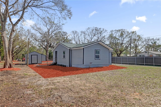 back of house featuring a storage unit and a yard