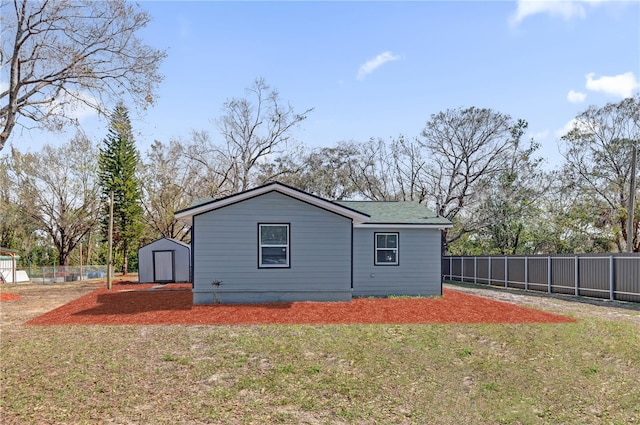 view of property exterior with a lawn and a storage unit