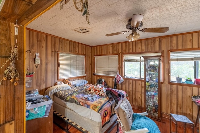 bedroom with dark wood-type flooring, wooden walls, and crown molding