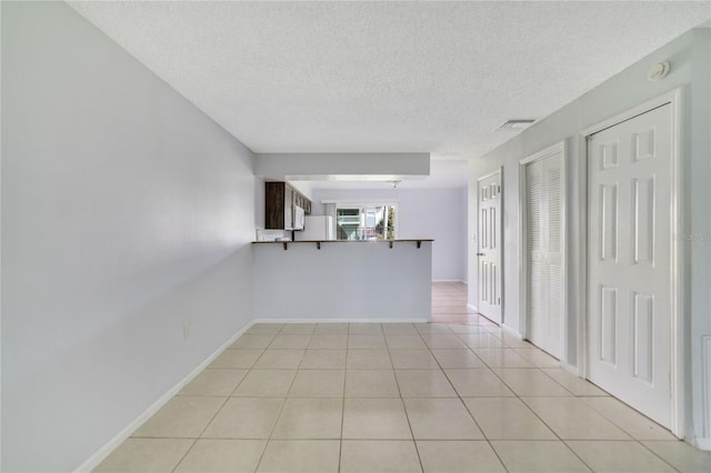 tiled spare room with a textured ceiling