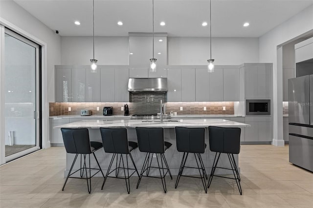 kitchen with under cabinet range hood, stainless steel appliances, white cabinets, modern cabinets, and a sink