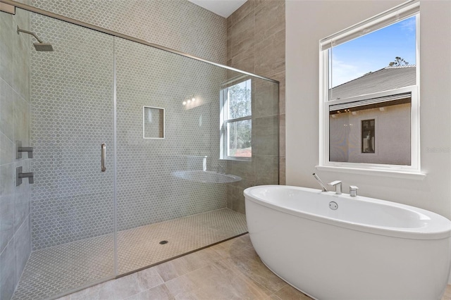 bathroom with a shower stall and a freestanding tub