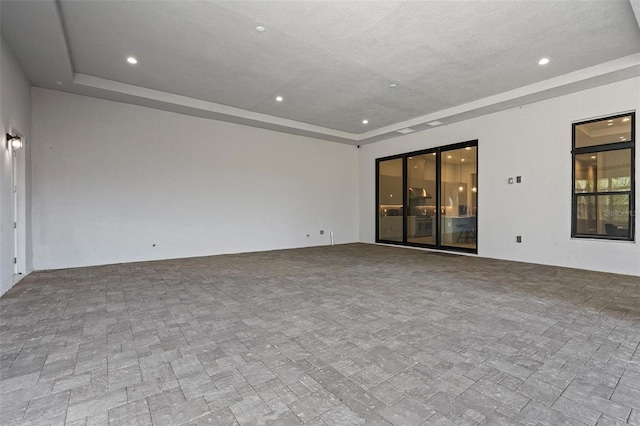 empty room with recessed lighting and a raised ceiling