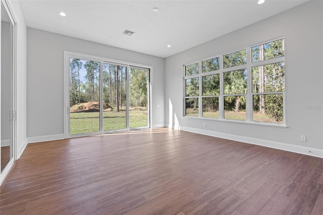 unfurnished room featuring recessed lighting, visible vents, baseboards, and wood finished floors