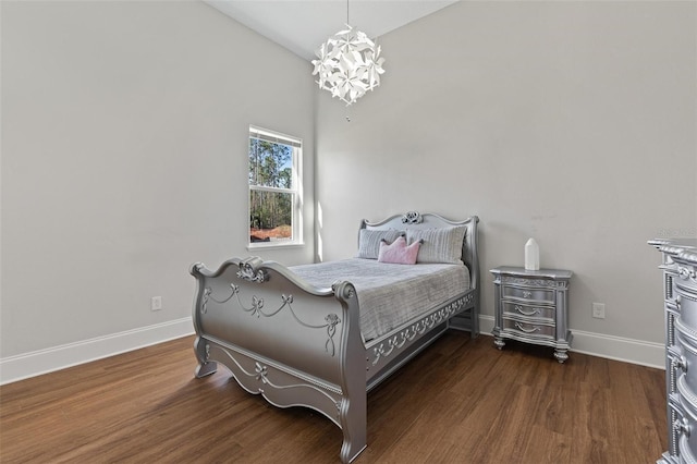 bedroom with baseboards, lofted ceiling, and wood finished floors