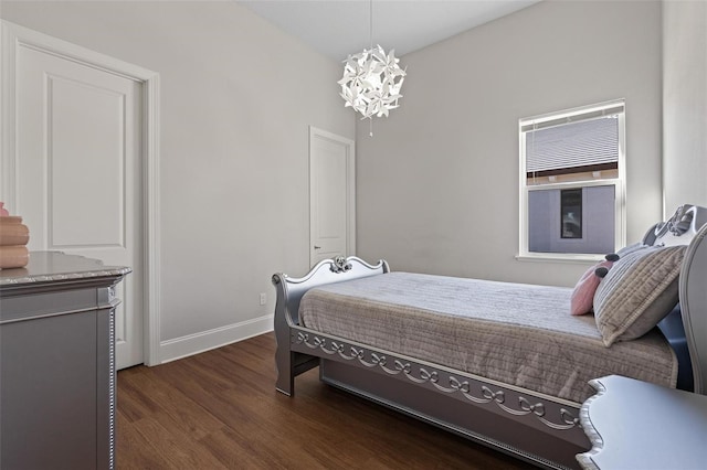 bedroom with dark wood finished floors, a notable chandelier, and baseboards