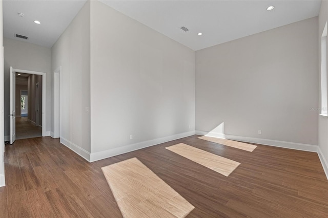 unfurnished room with recessed lighting, wood finished floors, visible vents, and baseboards