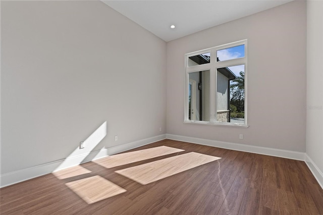 spare room with wood finished floors and baseboards