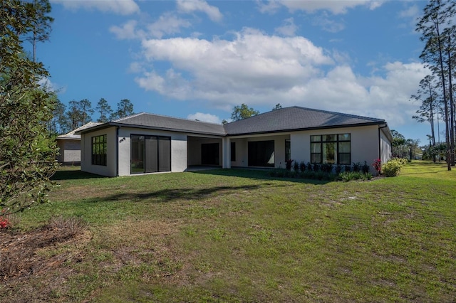 back of property featuring stucco siding and a lawn