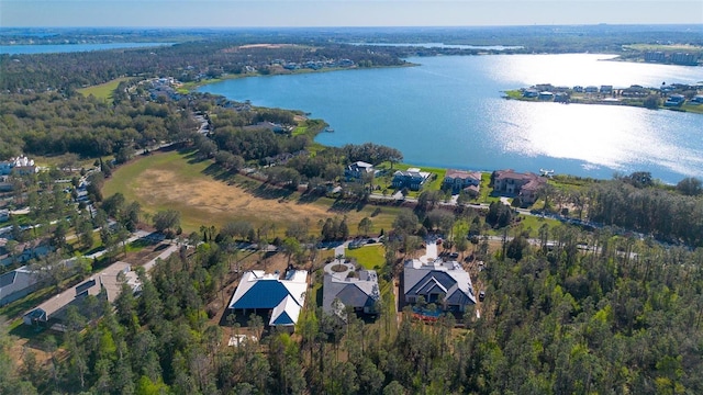 birds eye view of property with a water view and a wooded view