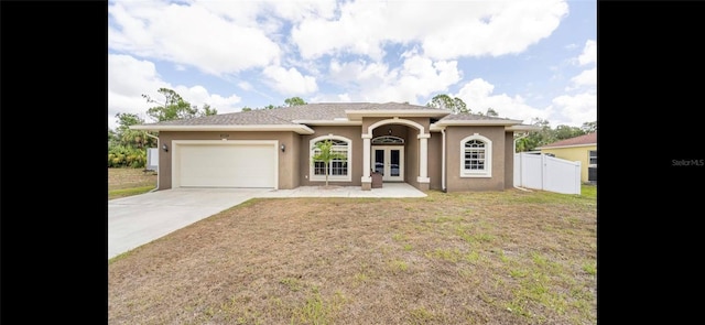 view of front of property featuring french doors, a garage, and a front lawn