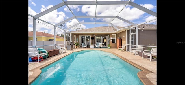 view of pool with grilling area, a lanai, and a patio area