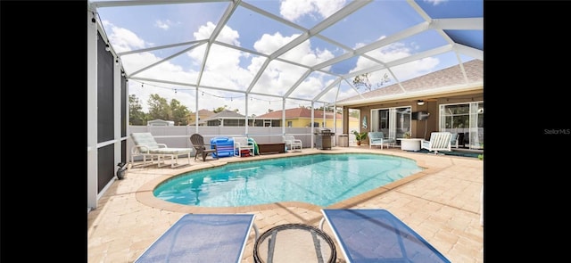 view of swimming pool featuring a lanai and a patio area