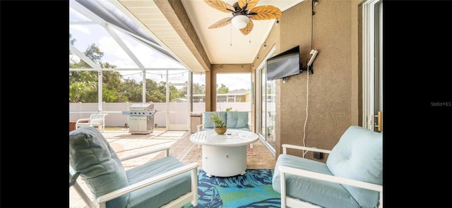 sunroom / solarium featuring beamed ceiling and ceiling fan