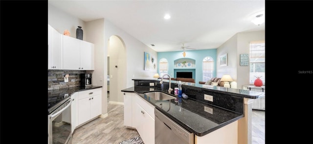 kitchen featuring stainless steel appliances, white cabinetry, sink, and a kitchen island with sink