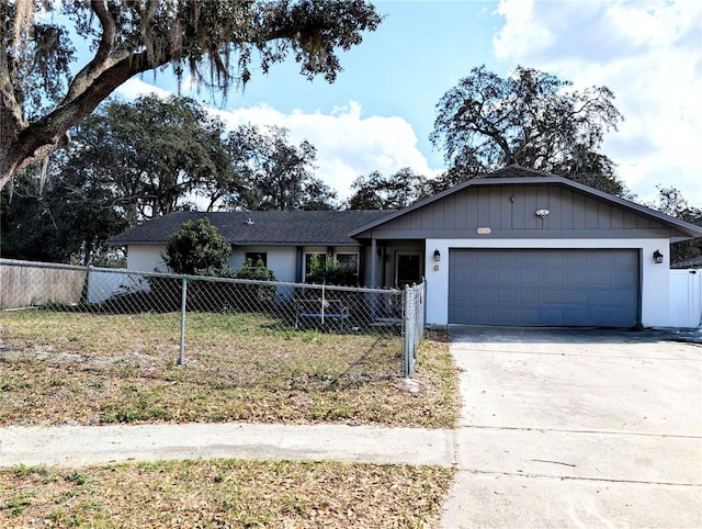 ranch-style home with a fenced front yard, concrete driveway, and an attached garage