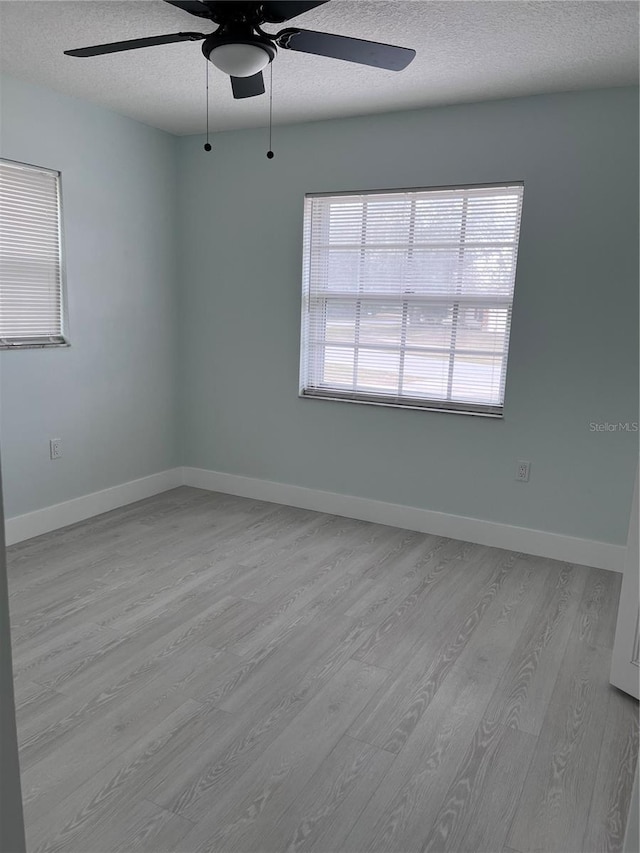 spare room featuring ceiling fan, a textured ceiling, and light hardwood / wood-style floors