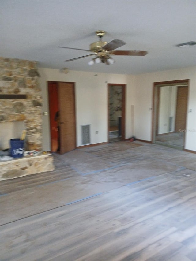 unfurnished living room featuring ceiling fan and light hardwood / wood-style flooring