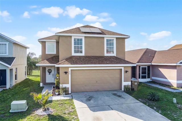 view of property with a front lawn, solar panels, and a garage