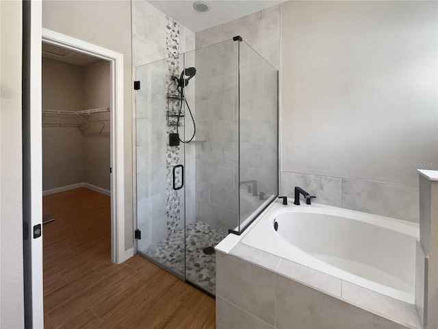 bathroom with wood-type flooring and plus walk in shower