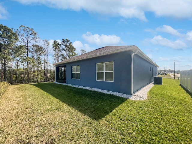 view of property exterior featuring central AC unit and a lawn