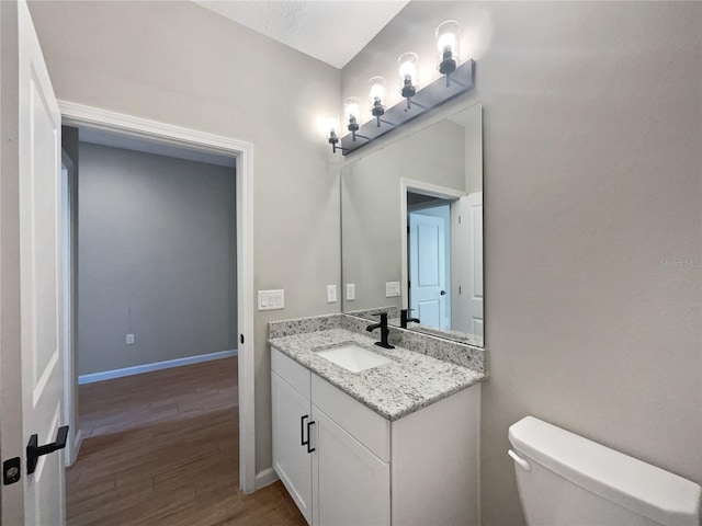 bathroom with vanity, hardwood / wood-style floors, and toilet