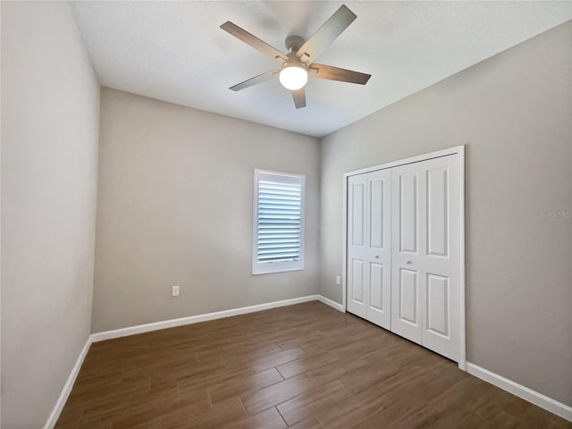 unfurnished bedroom featuring dark wood-type flooring, ceiling fan, and a closet