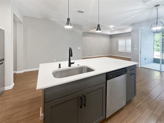 kitchen featuring hardwood / wood-style flooring, dishwasher, sink, and a center island with sink