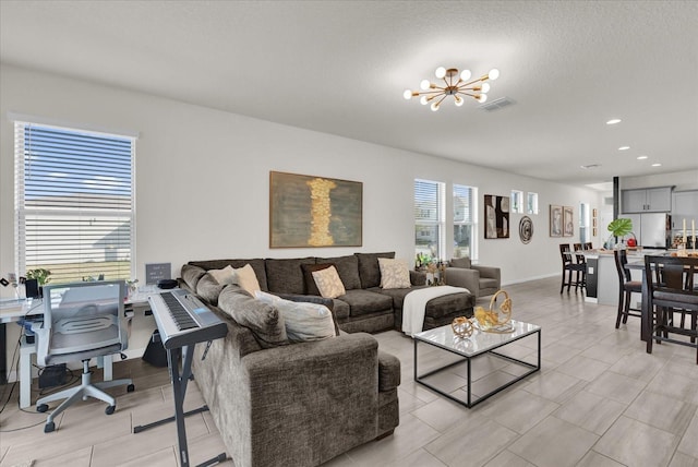 living room featuring a textured ceiling and an inviting chandelier