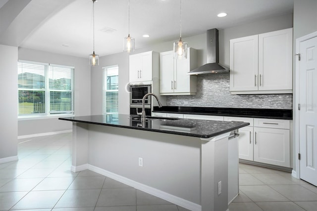 15165 Heron Hideaway Cir, Winter Garden, FL 34787 - kitchen featuring wall chimney exhaust hood, sink, white cabinetry, a center island with sink, and pendant lighting