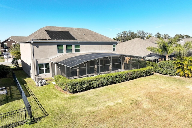15165 Heron Hideaway Cir, Winter Garden, FL 34787 - back of house featuring a yard, central air condition unit, glass enclosure, and solar panels