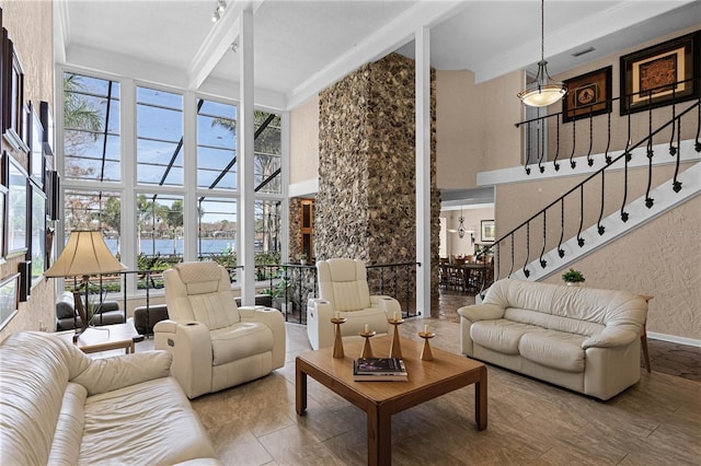 interior space with beam ceiling, a towering ceiling, and a water view