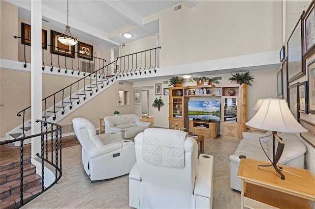 living room with beam ceiling and a high ceiling