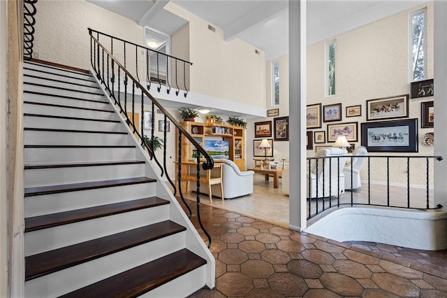 staircase featuring a towering ceiling