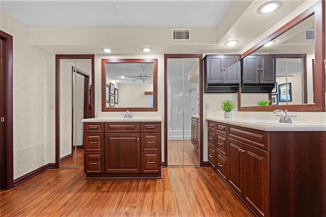 kitchen with sink, dark brown cabinets, and light wood-type flooring