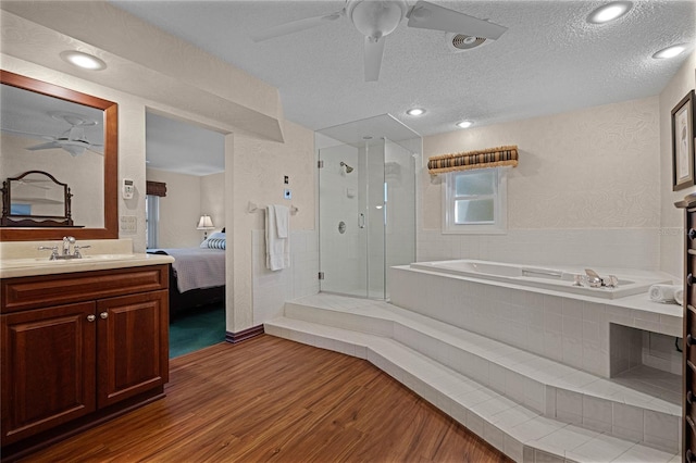 bathroom featuring hardwood / wood-style flooring, ceiling fan, vanity, and a textured ceiling