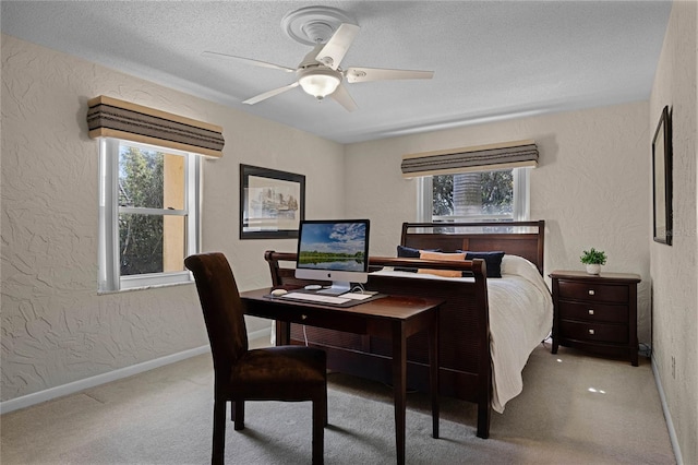 bedroom featuring ceiling fan, light carpet, and a textured ceiling