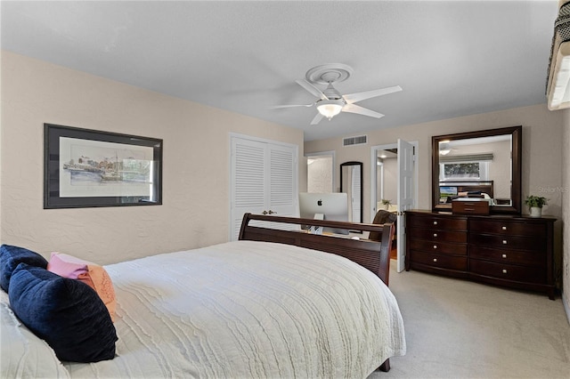 carpeted bedroom with ceiling fan and a closet