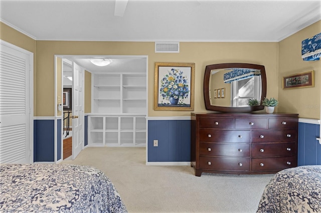 bedroom with crown molding, light colored carpet, a closet, and ceiling fan