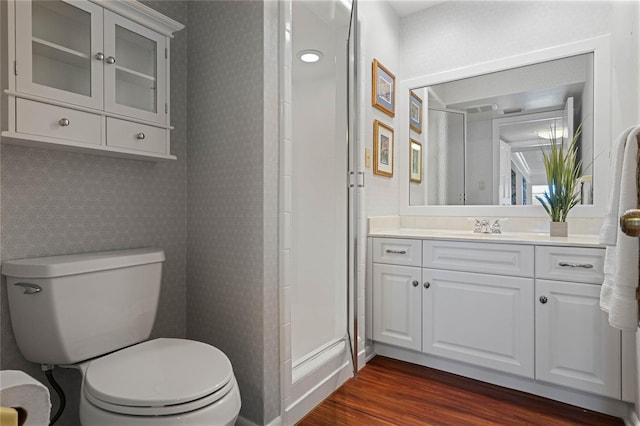 bathroom featuring vanity, hardwood / wood-style floors, toilet, and walk in shower