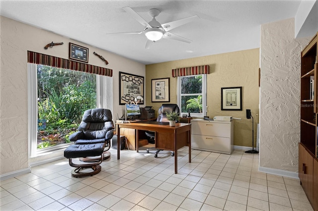 tiled office featuring ceiling fan, a wealth of natural light, and a textured ceiling