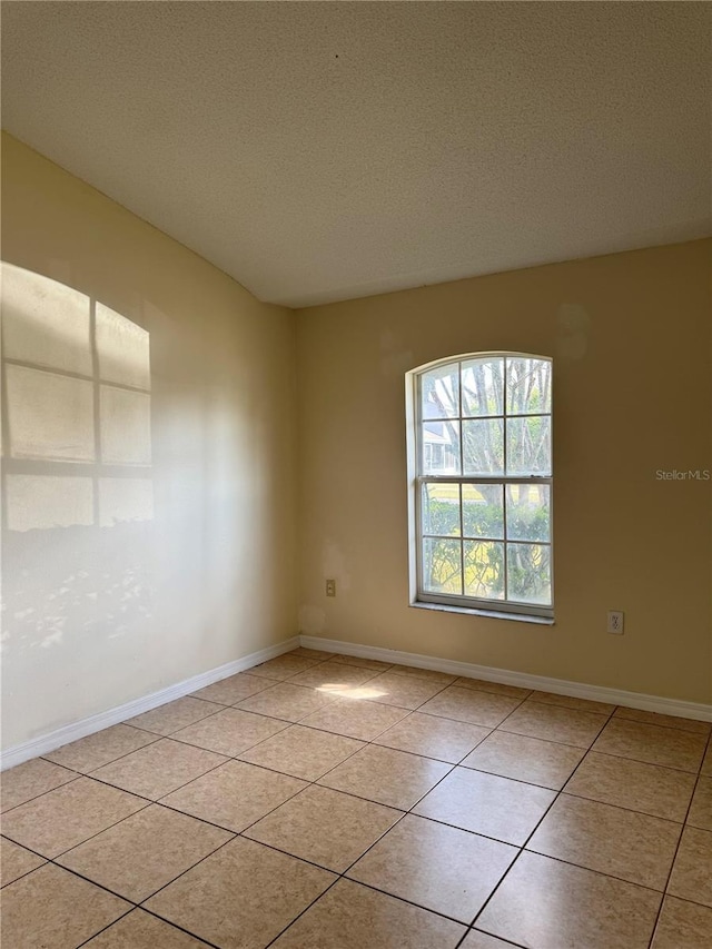 13900 Corrine Key Pl, Orlando, FL 32824 - empty room featuring light tile patterned floors, a textured ceiling, and baseboards