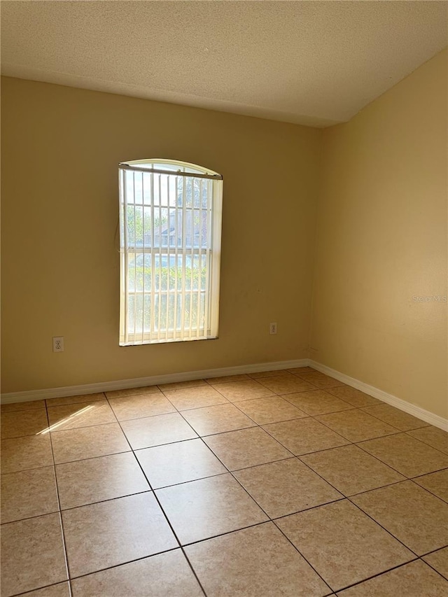 13900 Corrine Key Pl, Orlando, FL 32824 - unfurnished room with light tile patterned floors, baseboards, and a textured ceiling