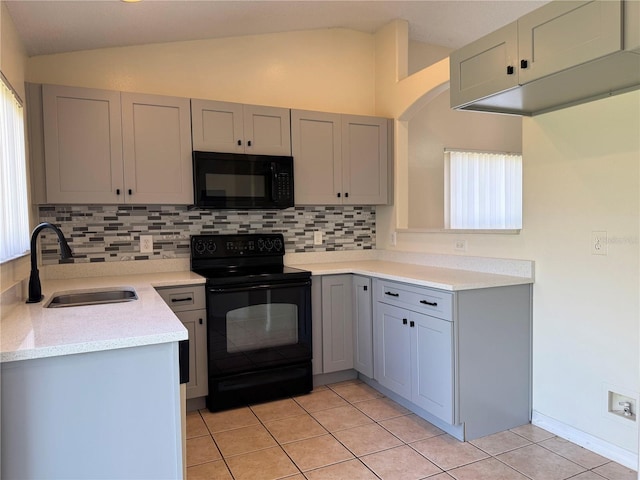 13900 Corrine Key Pl, Orlando, FL 32824 - kitchen featuring black appliances, a sink, lofted ceiling, gray cabinets, and decorative backsplash